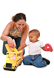 A woman and child playing with a toy truck