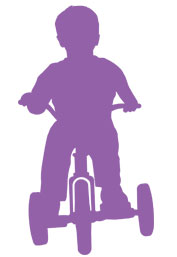 Silhouette of little boy on a tricyle